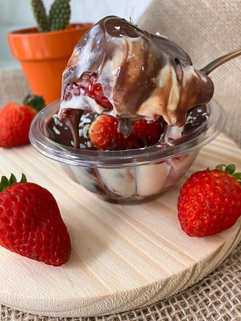 Pote de morango com creme e chocolate derretido